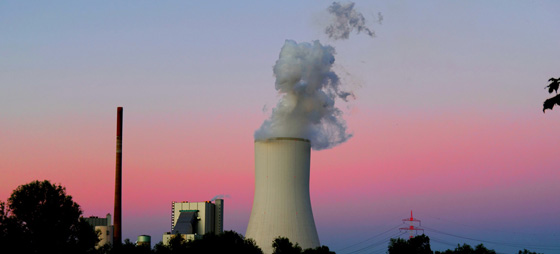 Ein Kohlekraftwerk mit rauchendem Turm im Sonnenuntergang