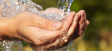 Wasser fließt in eine Hand
