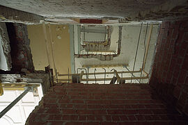 Blick in ein entkerntes Treppenhaus vor seiner Rekonstruktion.